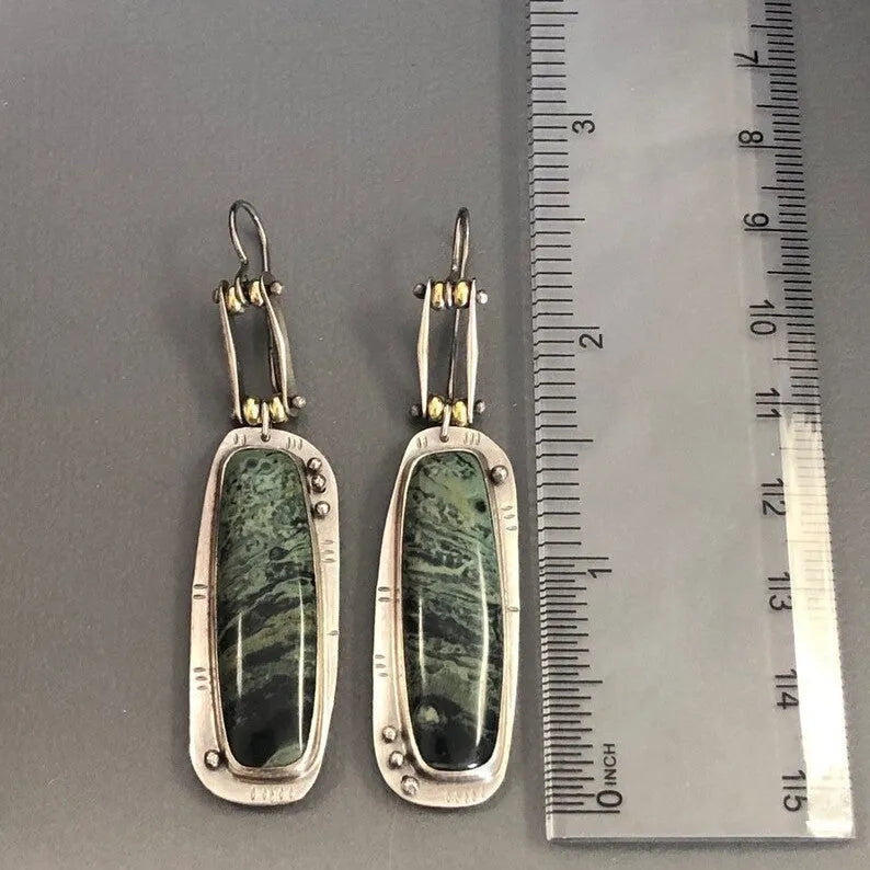 A pair of geometric-shaped alloy earrings with a white and grey marble pattern.