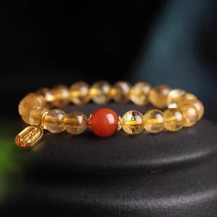 Natural red agate lucky beads bracelet with gold ruby accents on a wrist.