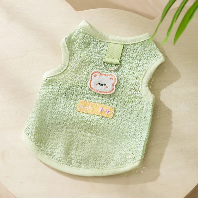 Green knitted cat clothing with a cartoon bear patch, showing hollowed-out breathable fabric.