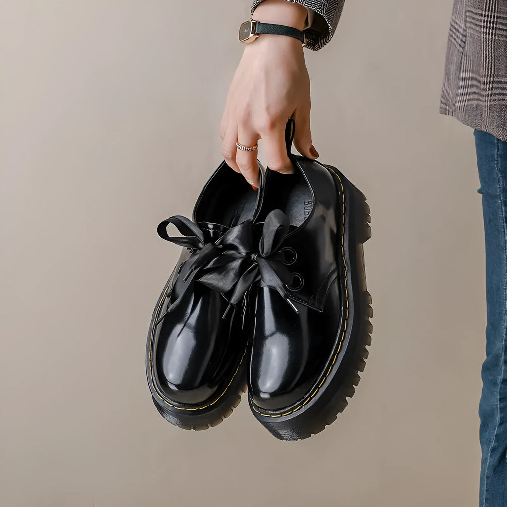 Women's white and black thick soled lace-up shoes with ribbon cross-straps on a superfine fibre upper.