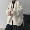 Women's loose black knitted cardigan coat with long sleeves on a hanger