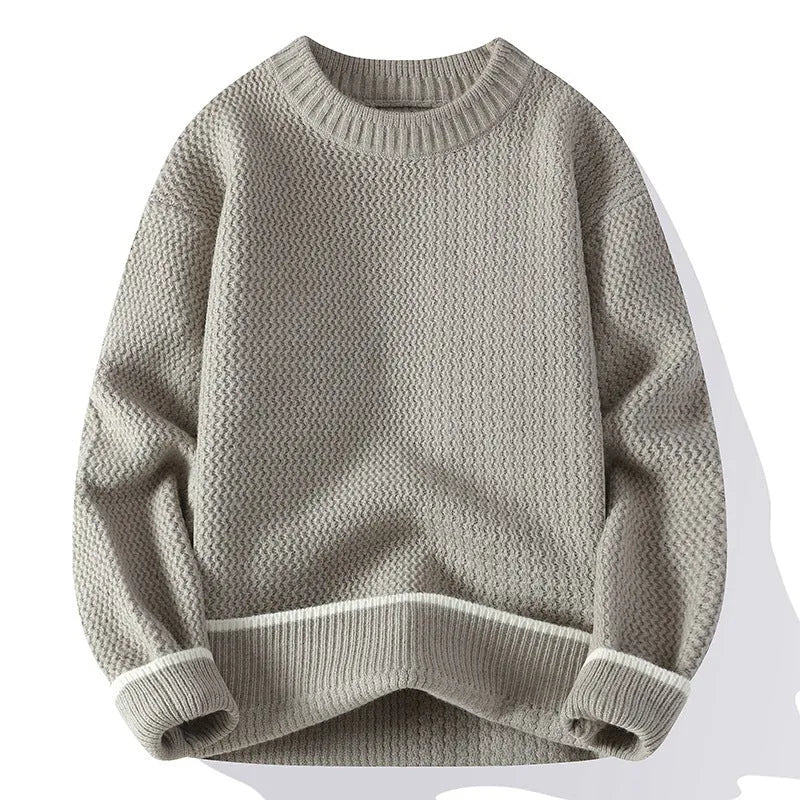 Man wearing a grey loose-fit round neck knitwear pullover sweater for casual autumn wear.