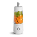 White portable USB rechargeable blender bottle with silicone lift ring, shown next to its charging cable.
