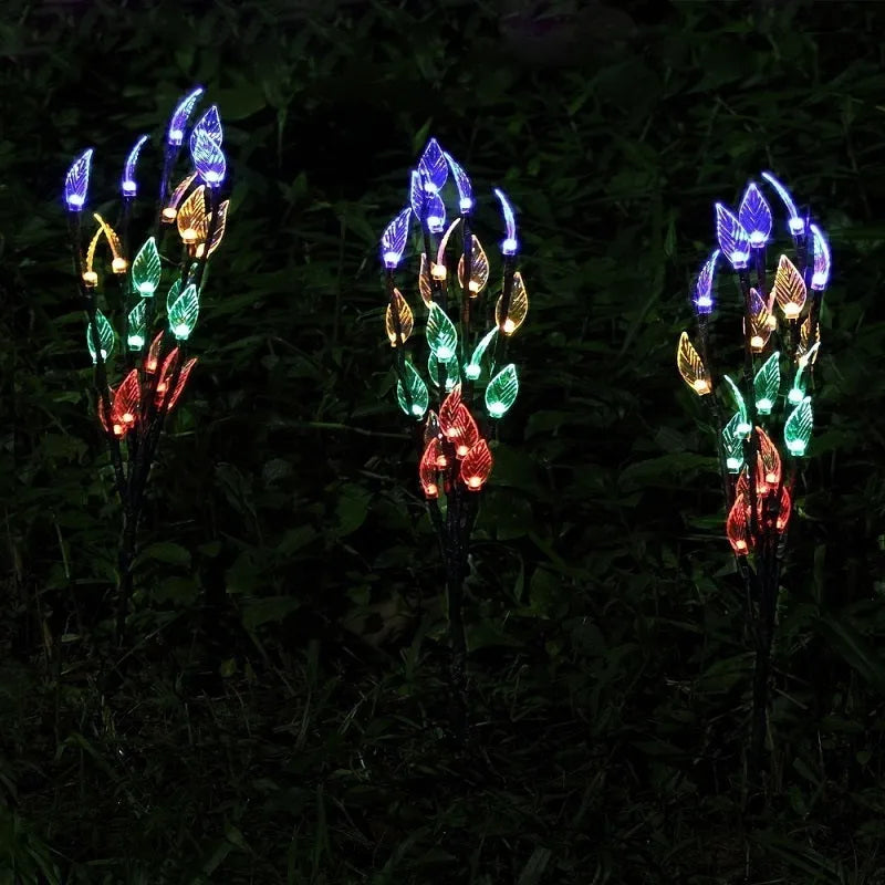 Three solar-powered garden lights with leaf branch design for lawn decoration