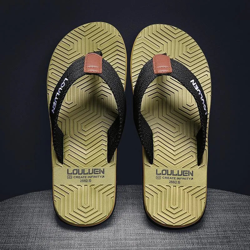 Men's black flip flops with textured non-slip sole on a beach background.