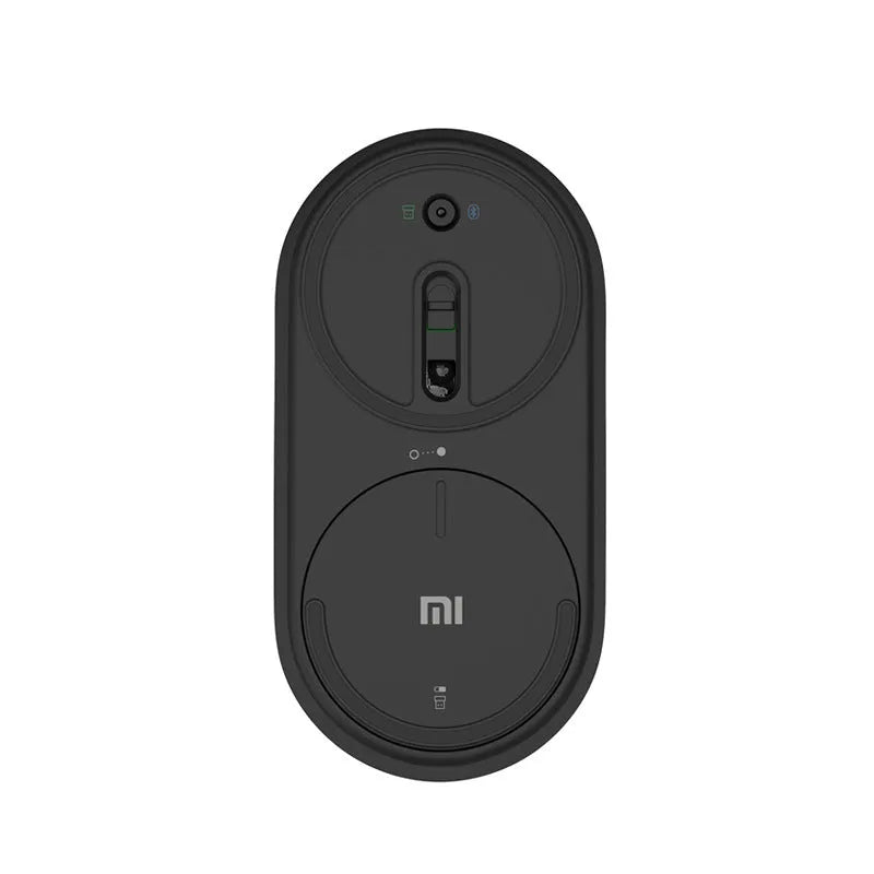 Black wireless Bluetooth mouse beside laptop showing compact design