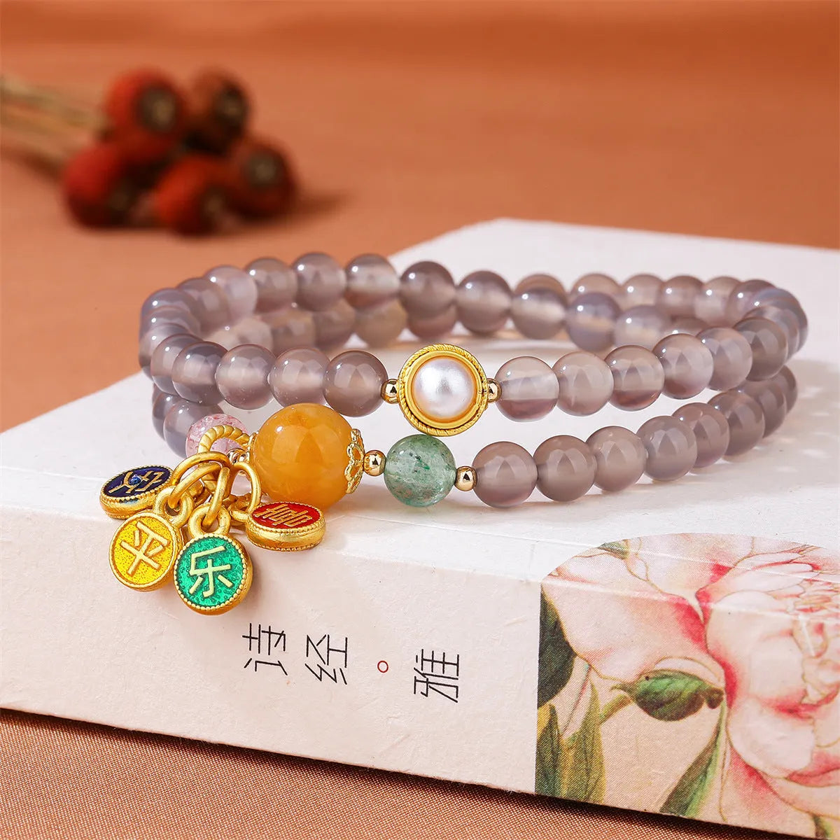 Close-up of a grey agate two-circle women's bracelet with a stainless steel clasp on a wrist.