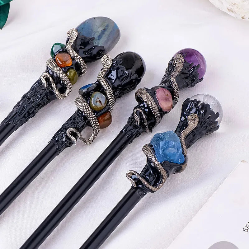 Natural crystal magic wand with labradorite stone ball on simple handle against neutral background