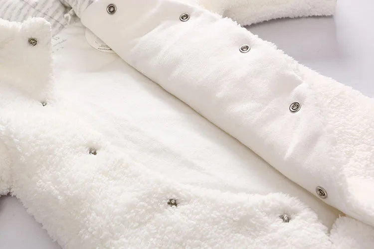 Newborn baby wearing a white cotton padded long sleeve romper jumpsuit