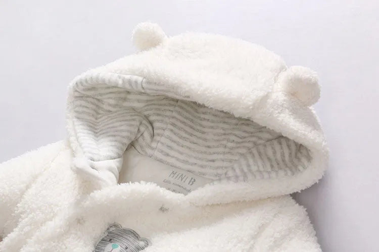 Newborn baby wearing a white cotton padded long sleeve romper jumpsuit