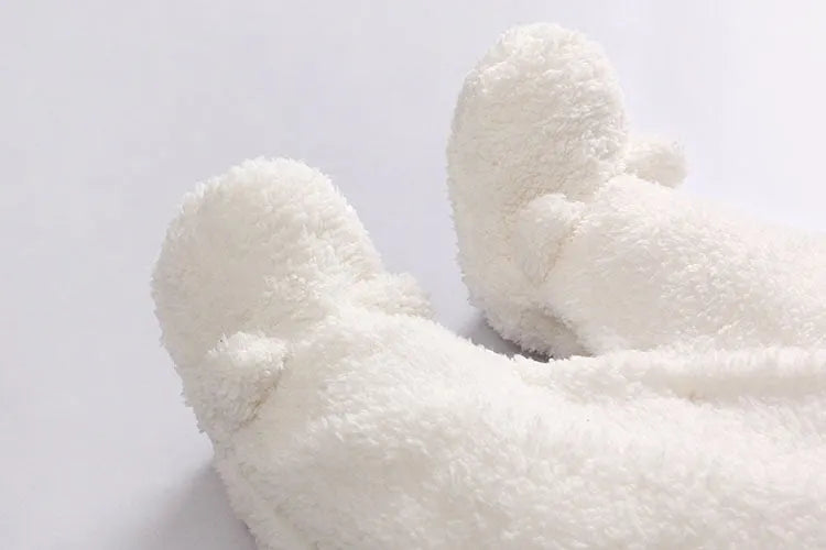Newborn baby wearing a white cotton padded long sleeve romper jumpsuit