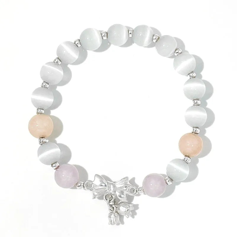 Lavender amethyst opal bracelet with a silver-toned bowknot design on a wrist.
