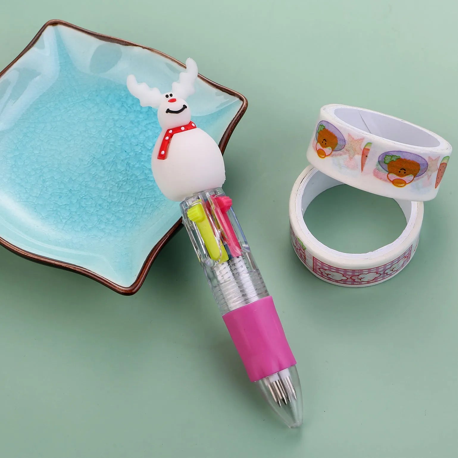 Compact 11cm Christmas ballpoint pen with four colours and festive designs like snowmen and reindeer.