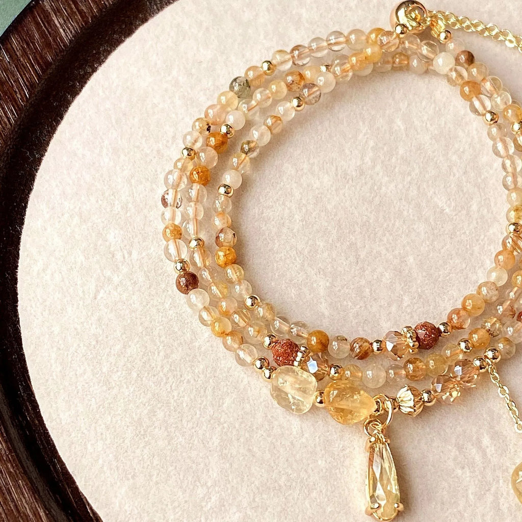 Caramel coloured citrine crystal women's bracelet with multi-layer design and Saturn decorative elements