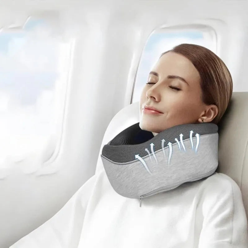 Navy blue U-shaped travel neck pillow rolled up next to its carry bag