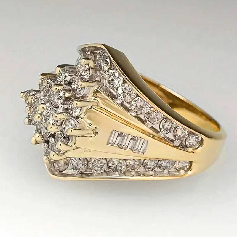 Geometric gold-coloured palace style fashion ring on a plain background, showing its angular design.