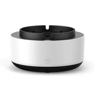 Grey electronic air purifier ashtray with cigarette butt grooves on a table