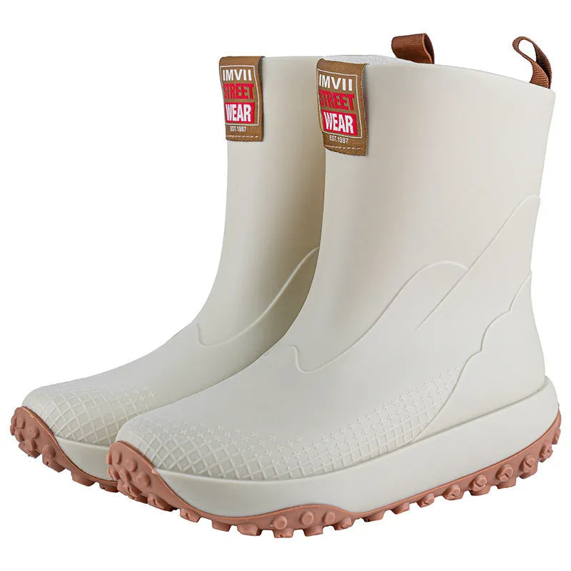Men's black red PVC rain boot with round toe and plastic sole on a wet surface
