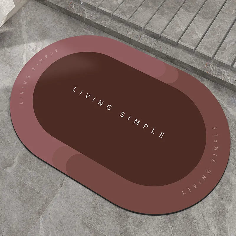 Oval grey polyester door mat with textured rubber non-slip backing on a wooden floor.