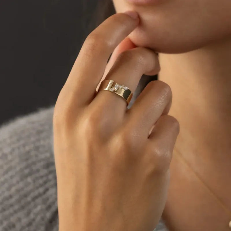 Gold electroplated copper ring for women with shining zircon details, shown on a finger.