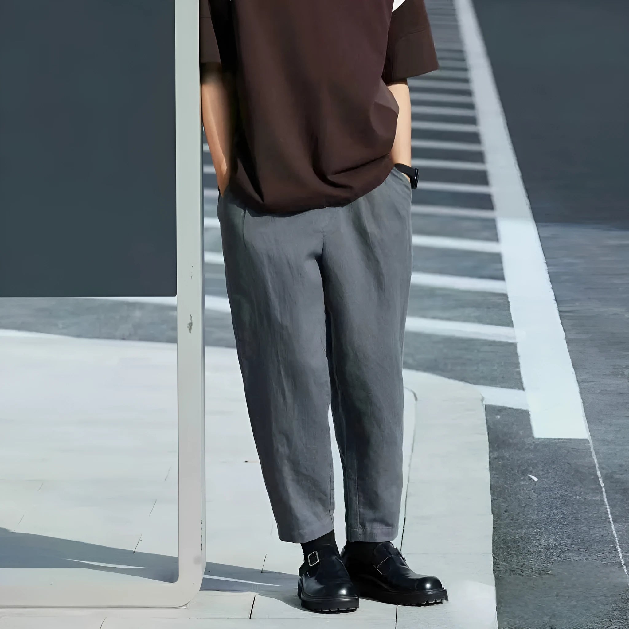 Men's beige loose straight leg casual trousers with an elasticated drawstring waistband laid flat.