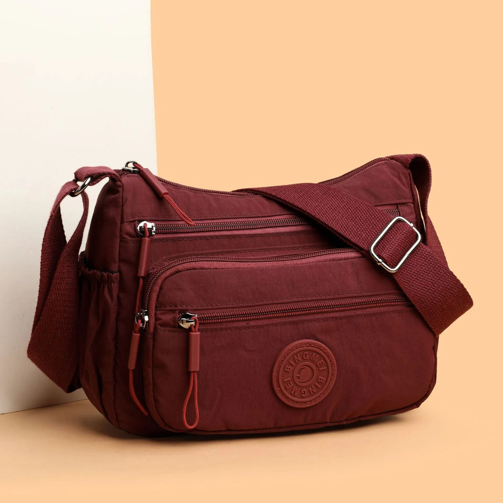 Soft water-repellent nylon crossbody bag showing three-dimensional pocket and adjustable shoulder strap
