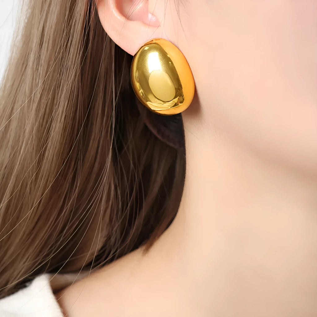 Geometric stainless steel ear studs with 18K gold plating and a glazed surface finish.
