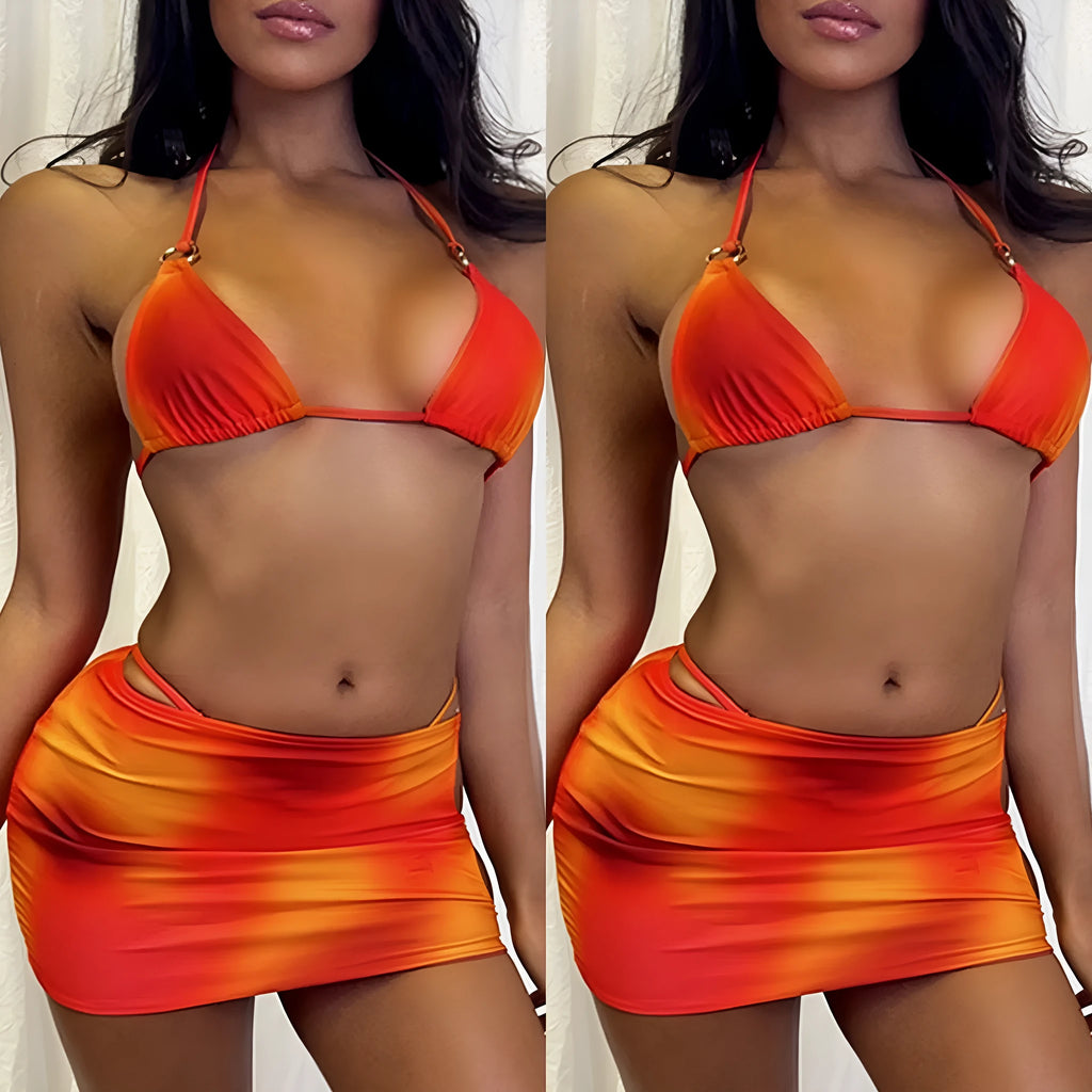 Tie-dye gradient three-piece women's bikini set with halter neck top, briefs, and matching skirt on a neutral background.