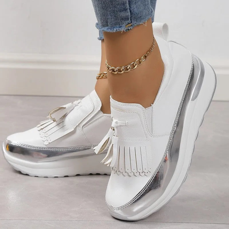 Women's black casual platform shoes with a tassel detail and a distinctive muffin-style wedge heel.