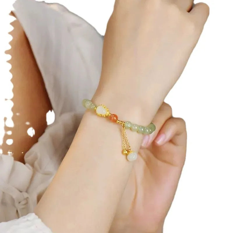 Natural jade bead bracelet with a gold-plated gourd charm and fu character.
