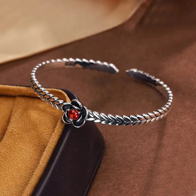 Silver zinc alloy retro bracelet with red zirconium plum flower centrepiece on white background