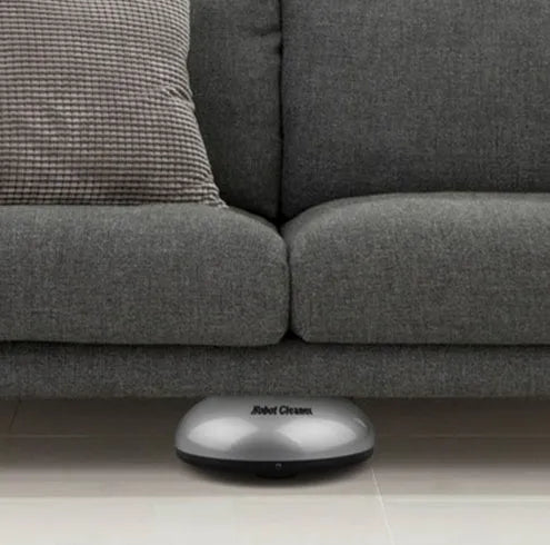 Compact silver automatic vacuum cleaner robot on a wooden floor