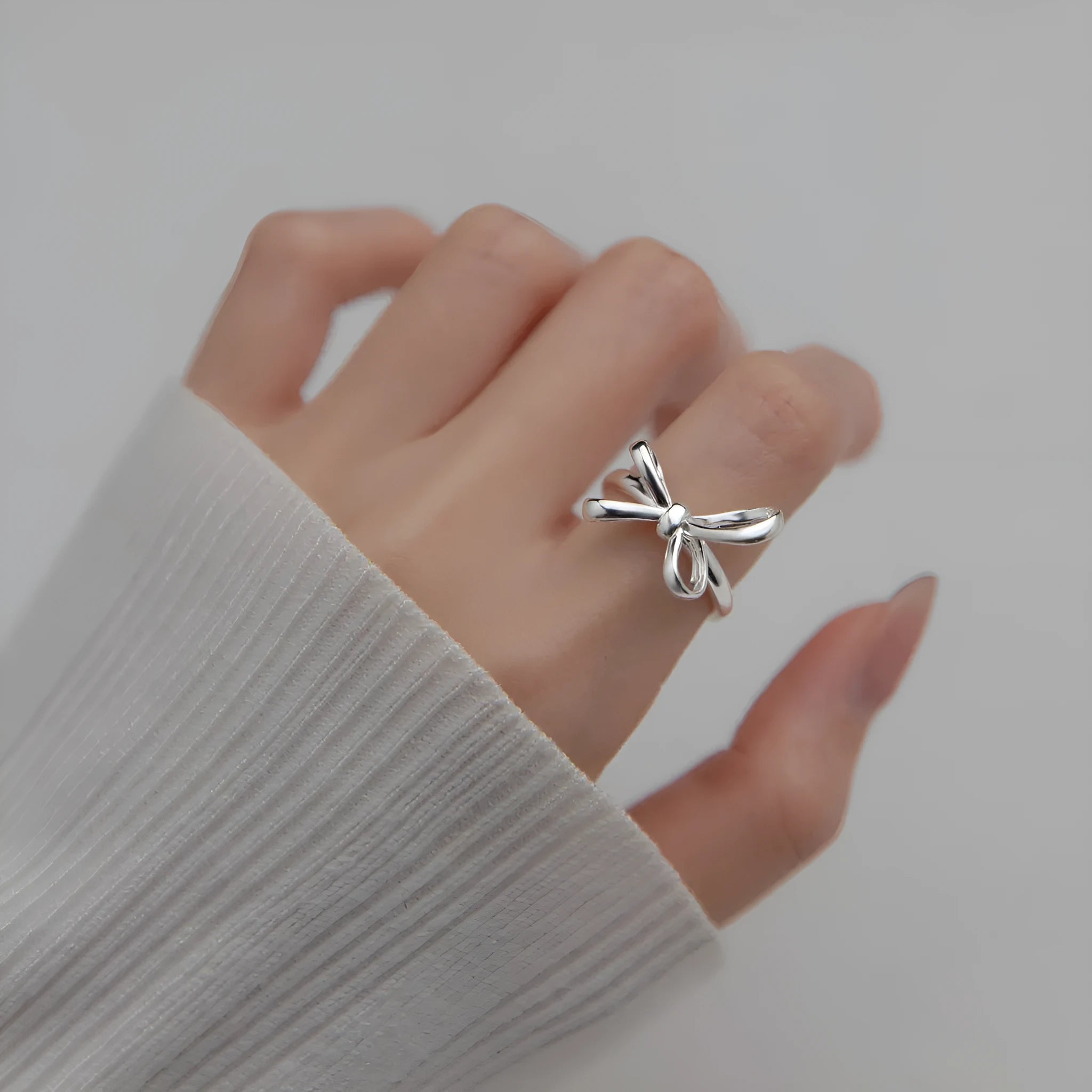 S925 silver bow ring with adjustable open band on hand, showing polished finish and Korean style design