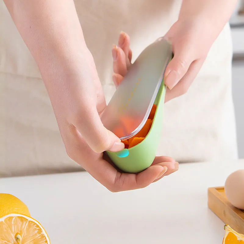 Dark green kitchen peeler with storage tube and stainless steel blade on a kitchen counter.