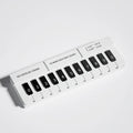 Black and white plastic piano-shaped temporary parking sign for car dashboards.