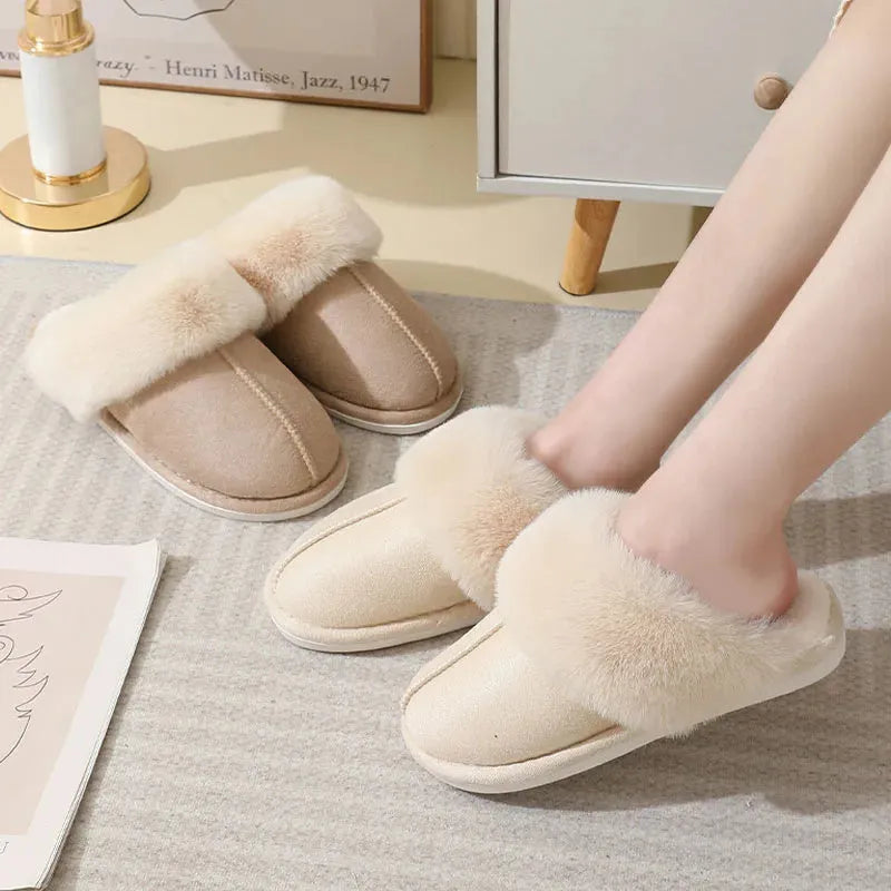 Women's brown plush indoor slippers with a round toe, flat heel, and stitching detail.