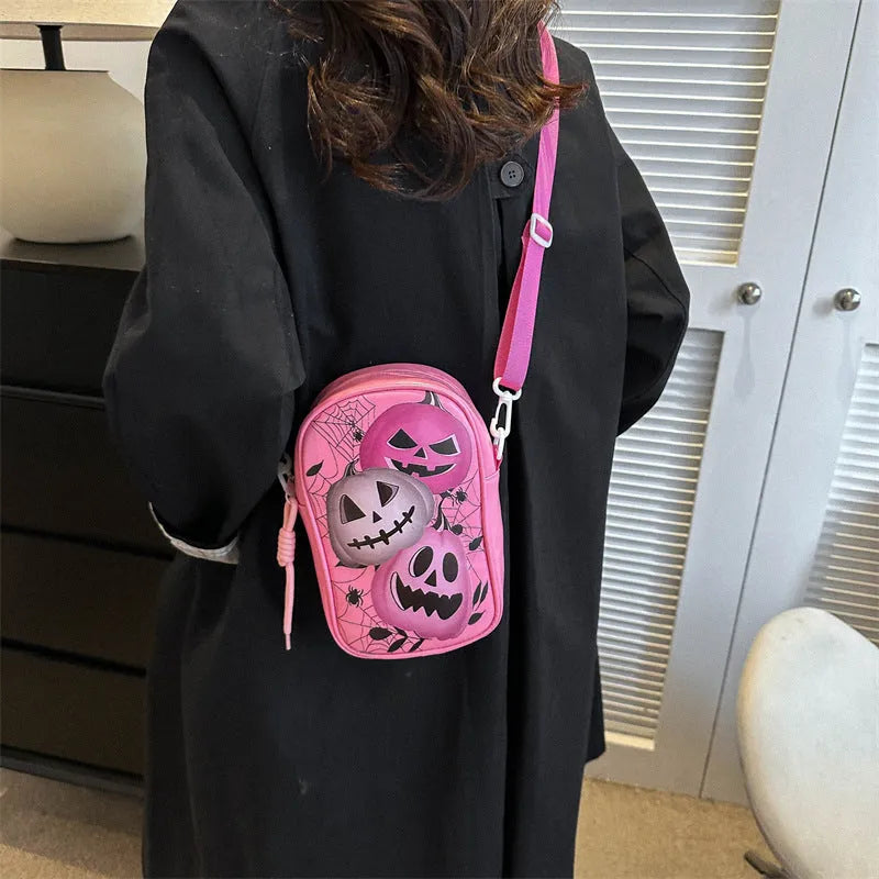Black Halloween graffiti crossbody bag with cartoon pumpkin, ghost, and bat print, shown with adjustable strap.