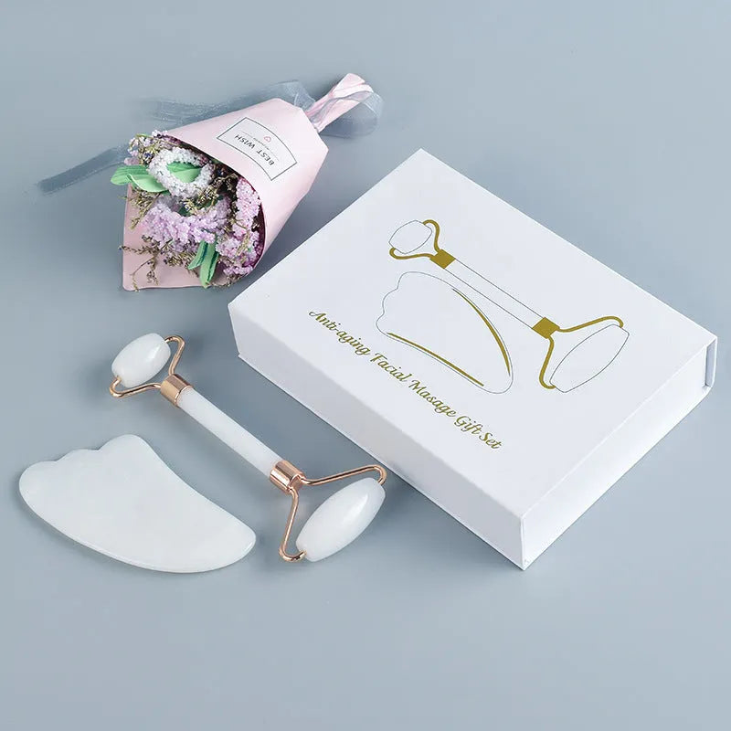 White jade double-headed facial roller and gua sha scraping tool set on a storage board.