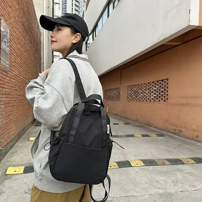 Solid colour nylon backpack with curved shoulder straps shown in five colour options
