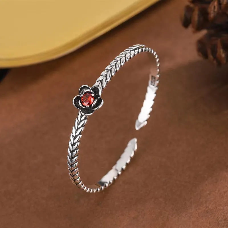 Silver zinc alloy retro bracelet with red zirconium plum flower centrepiece on white background
