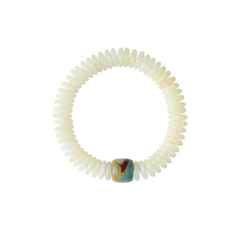 Close-up of a White Bodhi seed bracelet showing its 3x10mm beads and string.