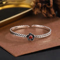 Silver zinc alloy retro bracelet with red zirconium plum flower centrepiece on white background