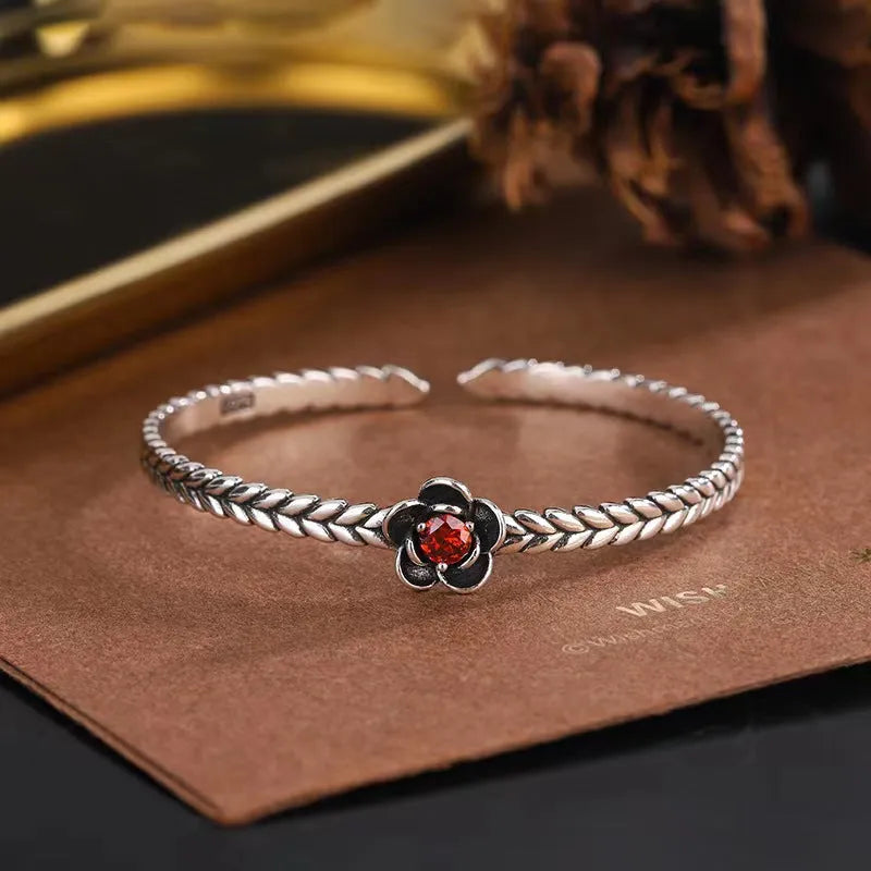Silver zinc alloy retro bracelet with red zirconium plum flower centrepiece on white background