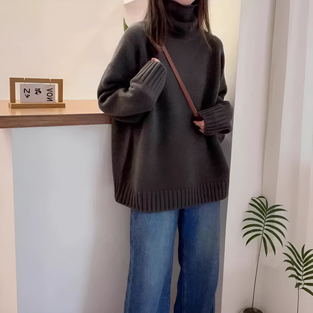 Women's loose fit grey turtleneck sweater with a thick curling pile collar on a hanger.