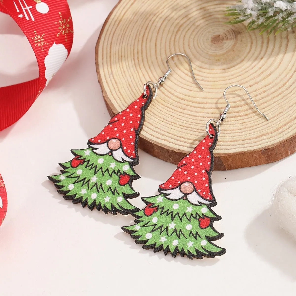 Pair of wooden geometric Christmas earrings with Santa Claus design in red and green colours.