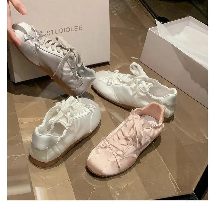 Women's satin ballet flat shoes with round toe and lace-up front in champagne pink colour