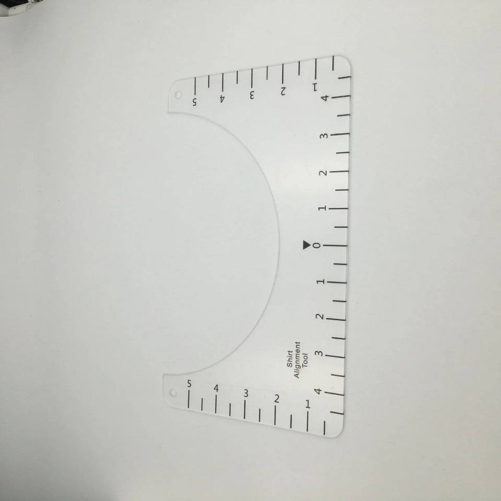 Transparent acrylic sewing ruler for T-shirt alignment and patch placement on fabric.