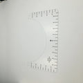 Transparent acrylic sewing ruler for T-shirt alignment and patch placement on fabric.