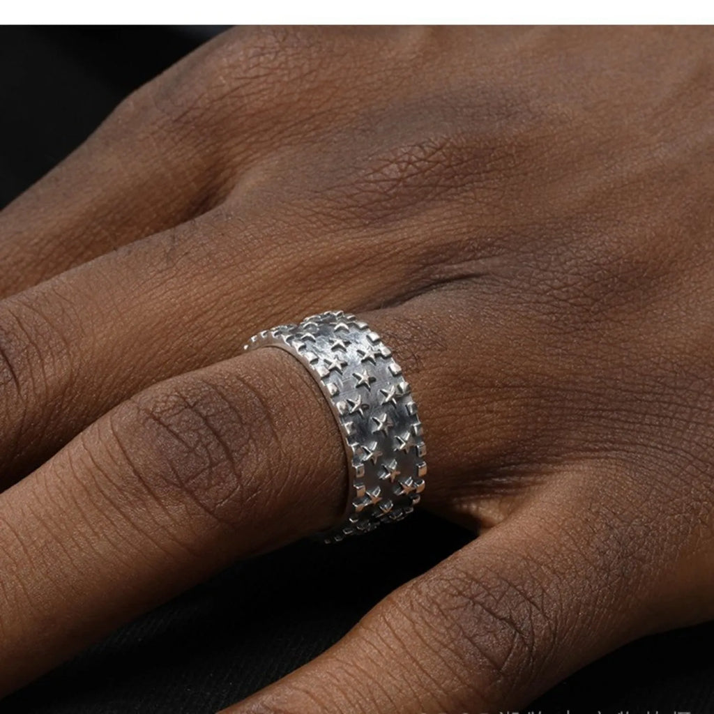 Adjustable sterling silver ring with a geometric pattern of five-pointed stars on the band.
