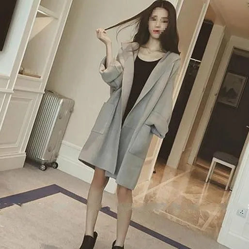 Plus size woman wearing a thin grey cotton coat with lace detail, loose fit long sleeves.